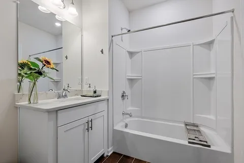 a bathroom with a sink double vanity granite tub shower and a mirror
