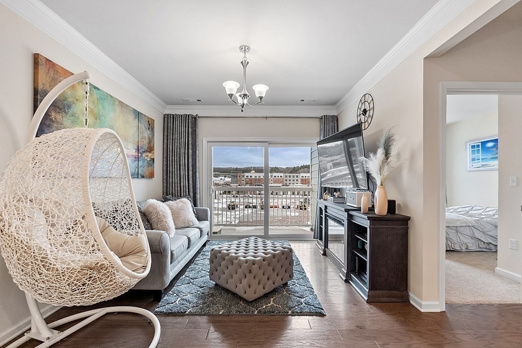 120 University Avenue, Unit 2308 Westwood, MA 02090 - Photo 5 of 20 a living room with furniture or couch and a chandelier