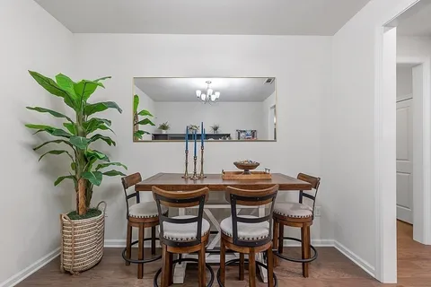 a dining room with furniture and a potted plant