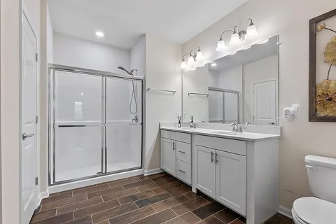 a bathroom with a double vanity sink mirror and toilet