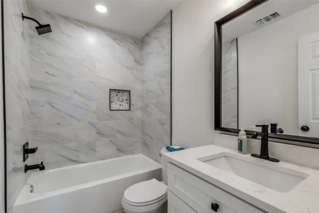 a bathroom with a granite countertop sink toilet and shower