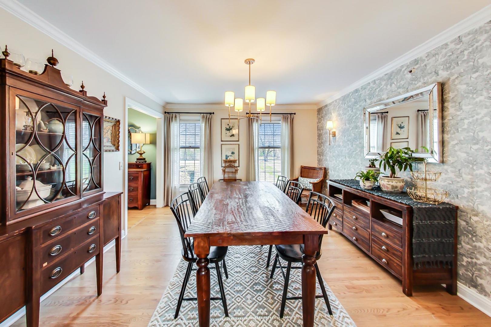 5258 Hilltop Road Long Grove, IL 60047 - Photo 10 of 50 a dining room with wooden floor a chandelier a wooden table and chairs