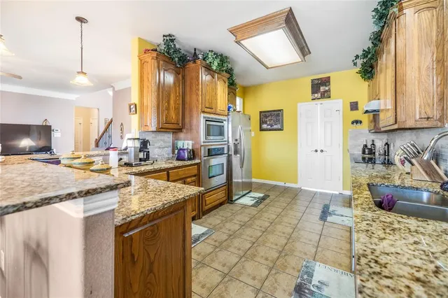a kitchen with stainless steel appliances granite countertop a sink stove and refrigerator