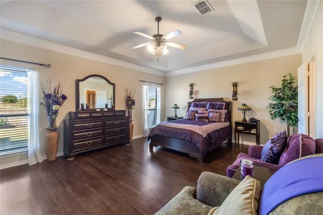 a spacious bedroom with a bed and wooden floor