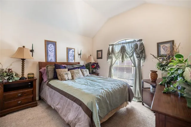 a bedroom with a bed and a potted plant on dresser