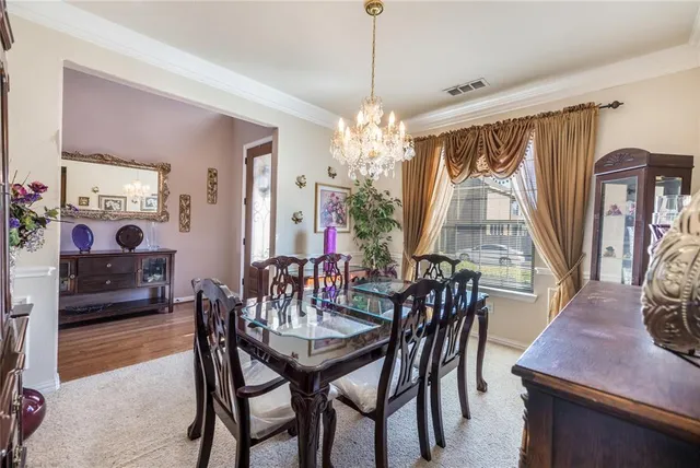 a view of a dining room with furniture and a chandelier