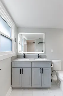 a bathroom with a granite countertop sink and a toilet