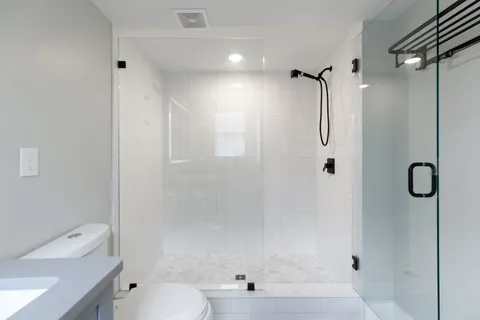 a bathroom with a shower toilet and sink
