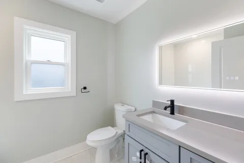 a bathroom with a sink a toilet and a window
