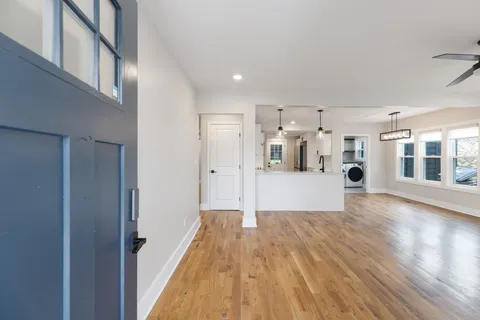 a view of a big room with wooden floor and windows