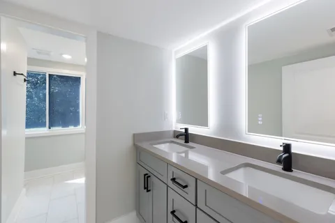 a bathroom with a double vanity sink and a mirror