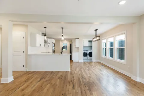 a view of a big room with wooden floor and windows