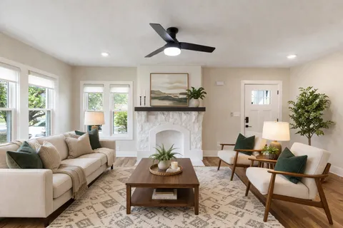 a living room with furniture a fireplace and a large window