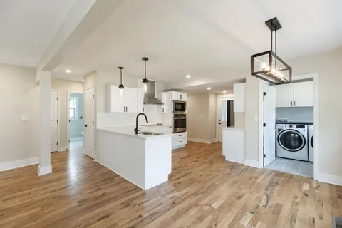 a view of a kitchen with stainless steel appliances kitchen island a refrigerator and a view of living room