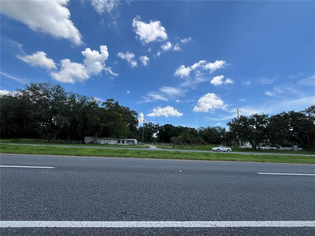 411 Alibrandi Road Leesburg, FL 34748 - Photo 2 of 44 a view of a golf course with a big yard