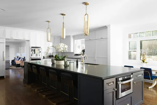 a kitchen with stainless steel appliances granite countertop a sink a stove and a wooden floors