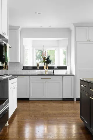 a kitchen with granite countertop white cabinets and a sink