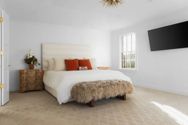 a bedroom with a bed and a flat screen tv