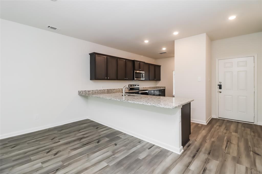 149 Switchback Hill Road Newark, TX 76071 - Photo 15 of 17 a kitchen with wooden floor microwave and refrigerator