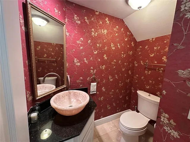 a bathroom with a toilet sink a mirror and vanity