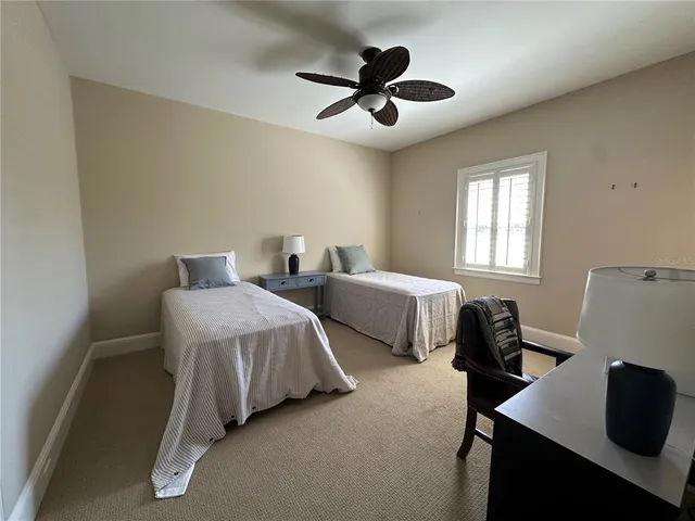 a spacious bedroom with two beds and a desk