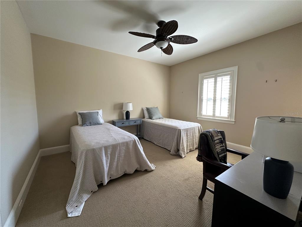 60 Bishopscourt Road, Unit 114 Osprey, FL 34229 - Photo 17 of 33 a spacious bedroom with two beds and a desk