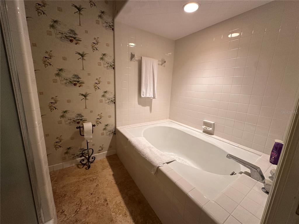 60 Bishopscourt Road, Unit 114 Osprey, FL 34229 - Photo 20 of 33 a bathroom with a bathtub and a shower