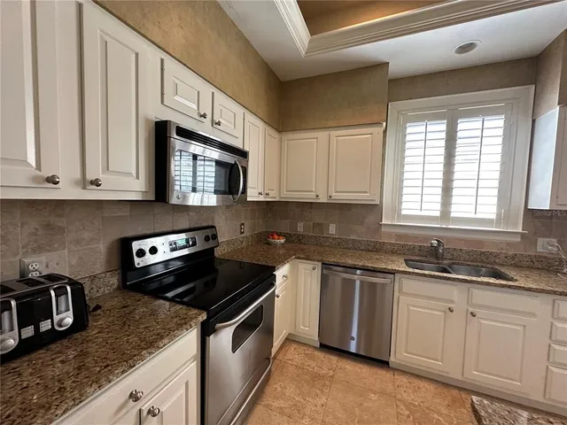 a kitchen with stainless steel appliances granite countertop a sink stove and cabinets