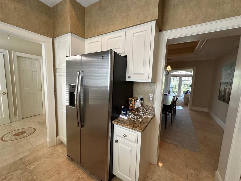 60 Bishopscourt Road, Unit 114 Osprey, FL 34229 - Photo 5 of 33 a kitchen with a refrigerator and a stove top oven