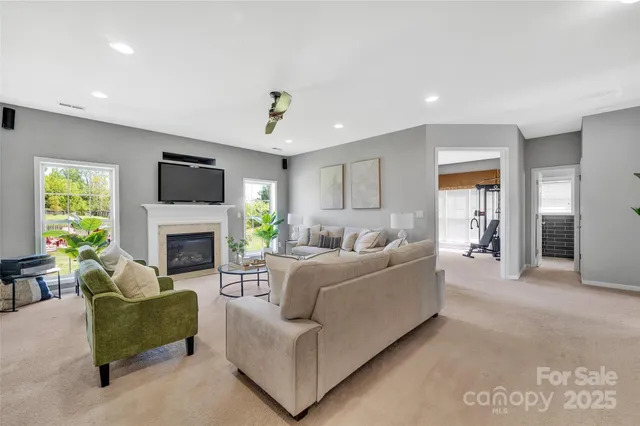 a living room with furniture a fireplace and a flat screen tv