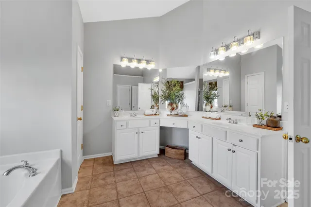 a bathroom with a double vanity sink mirror and bathtub