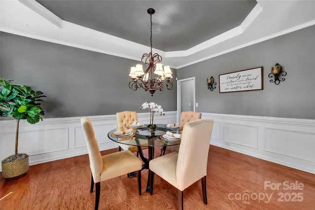 a dining room with furniture potted plants and wooden floor