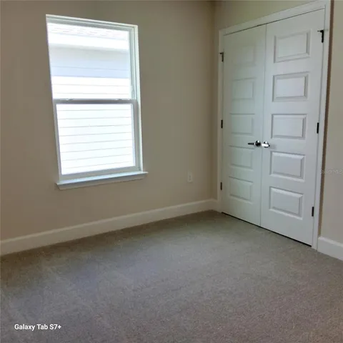 an empty room with closet and windows