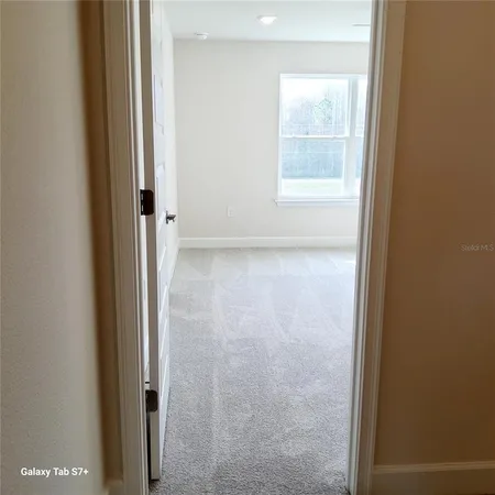 a view of a small space with wooden floor and a window