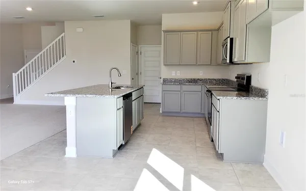 a kitchen with a sink a stove and cabinets