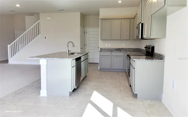 a kitchen with a sink a stove and cabinets