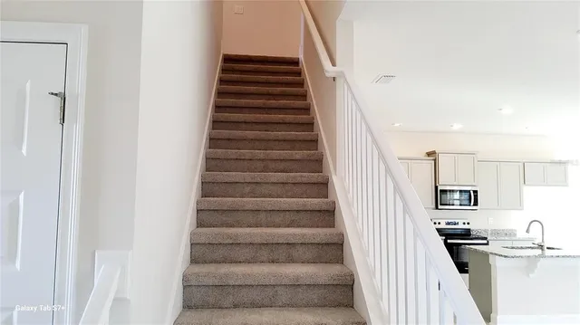 a view of a kitchen with furniture and staircase