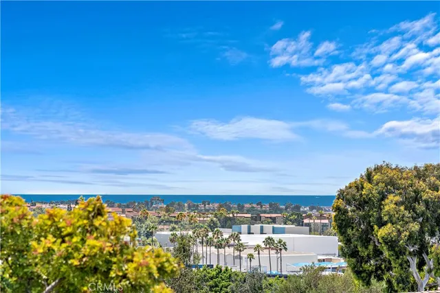 a large white kitchen with a large island oven a stove a sink a dining table and chairs