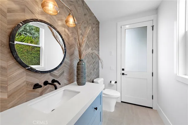 a large white kitchen with a sink and large mirror