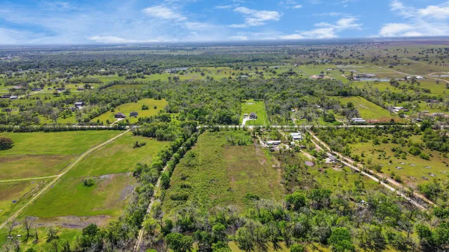 a view of a pathway both side of grassy field with shrub