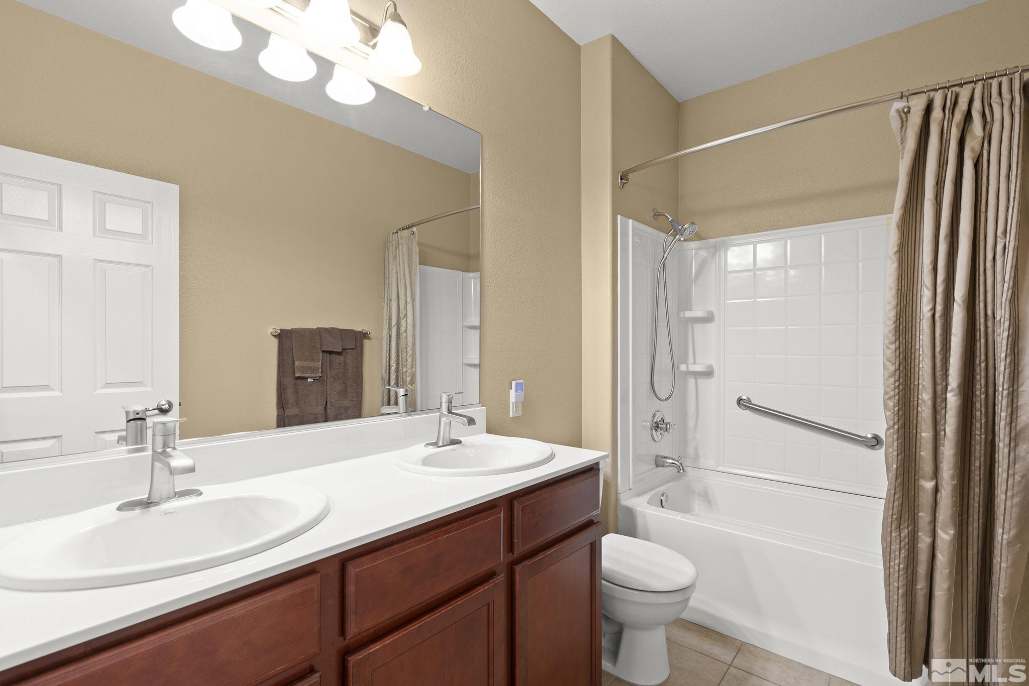 11053 Colton Drive Reno, NV 89521 - Photo 15 of 21 a bathroom with a sink a toilet a mirror and shower