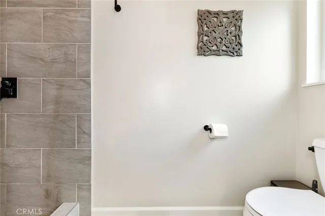 a white toilet sitting next to a white wall