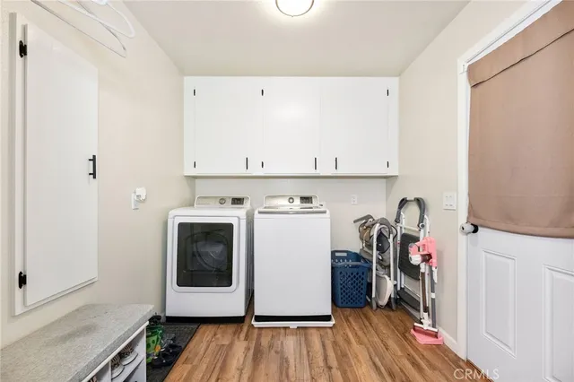 a utility room with wooden floor washer and dryer