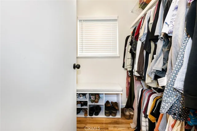 a view of walk in closet with clothes and shoes