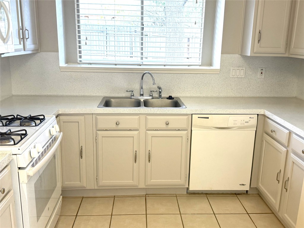 1412 Quail Run Road Pflugerville, TX 78660 - Photo 8 of 16 a kitchen with white cabinets and a stove top oven