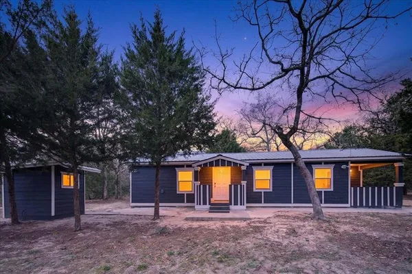 a house with lots of trees in the background