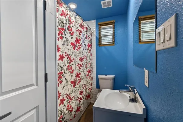 a bathroom with a sink and mirror with toilet