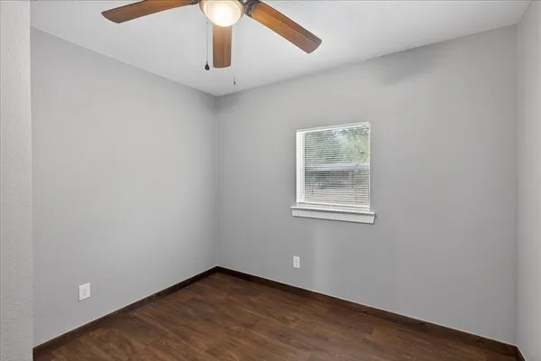 an empty room with a window and wooden floor