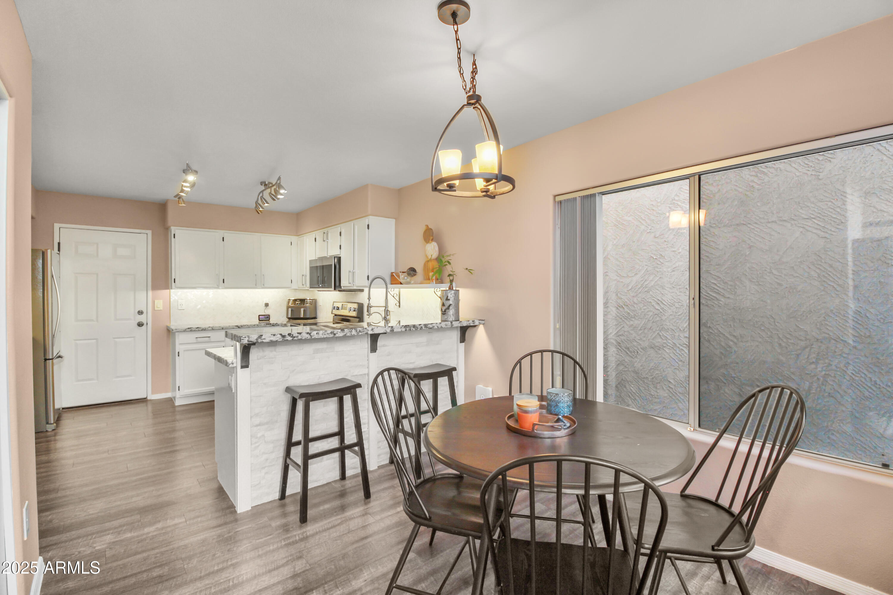 1122 West Sandy Banks Gilbert, AZ 85233 - Photo 8 of 22 a dining room with furniture a chandelier and wooden floor
