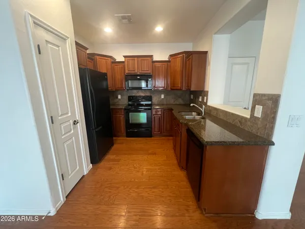a kitchen with stainless steel appliances granite countertop a refrigerator and a stove